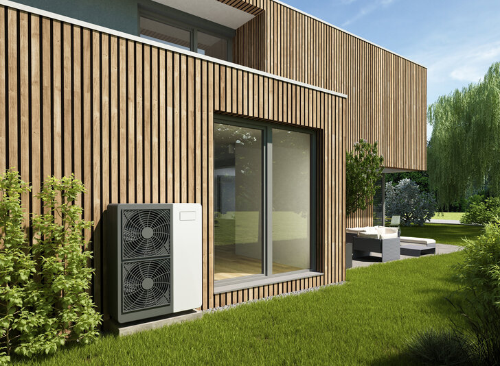 Bild mit modernem Holzhaus und Wärmepumpe im Vordergrund, mit Link zum Newsbeitrag